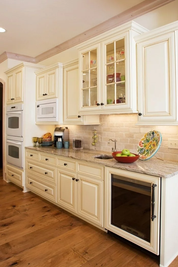 moderne Küche mit hellen Wandfliesen und Küchenschränken und einem Holzboden