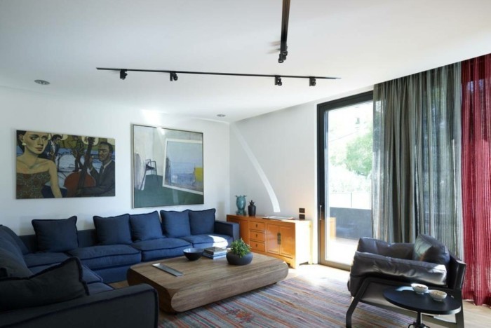 lampen wohnzimmer beleuchtung ideen dunkleblaues sofa holztisch streifenteppich wanddeko