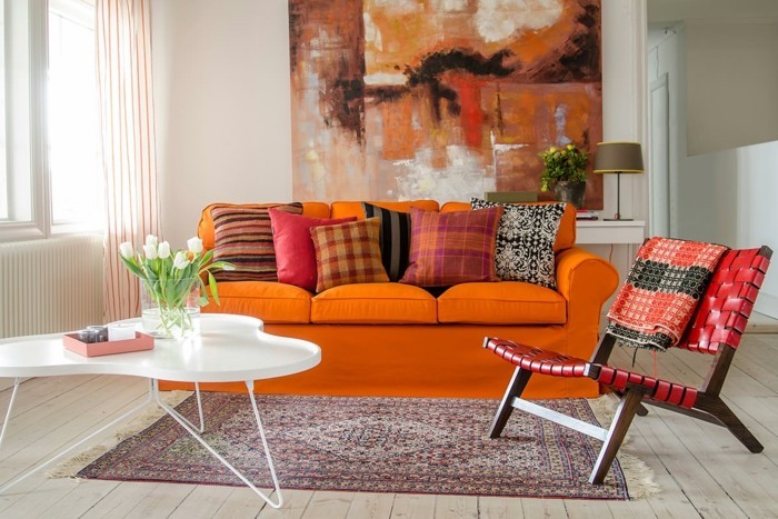 wandbilder wohnzimmer oranges sofa dekokissen teppich holzboden