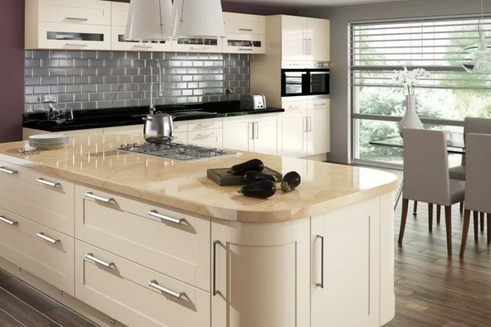 Küchendesign mit Kücheninsel in Creme, grauen Wandfliesen und Holzboden