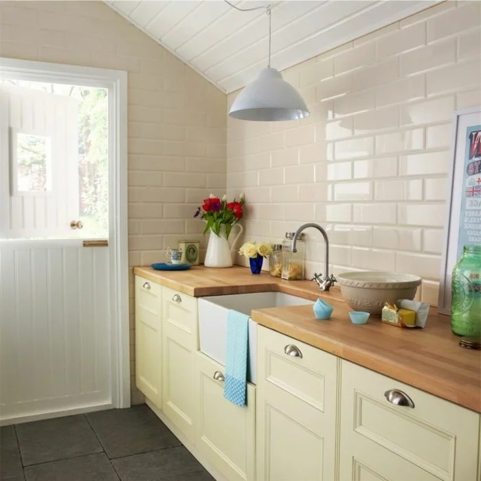 moderne Küche mit Wandfliesen und Küchenschränke in Creme und graue Bodenfliesen