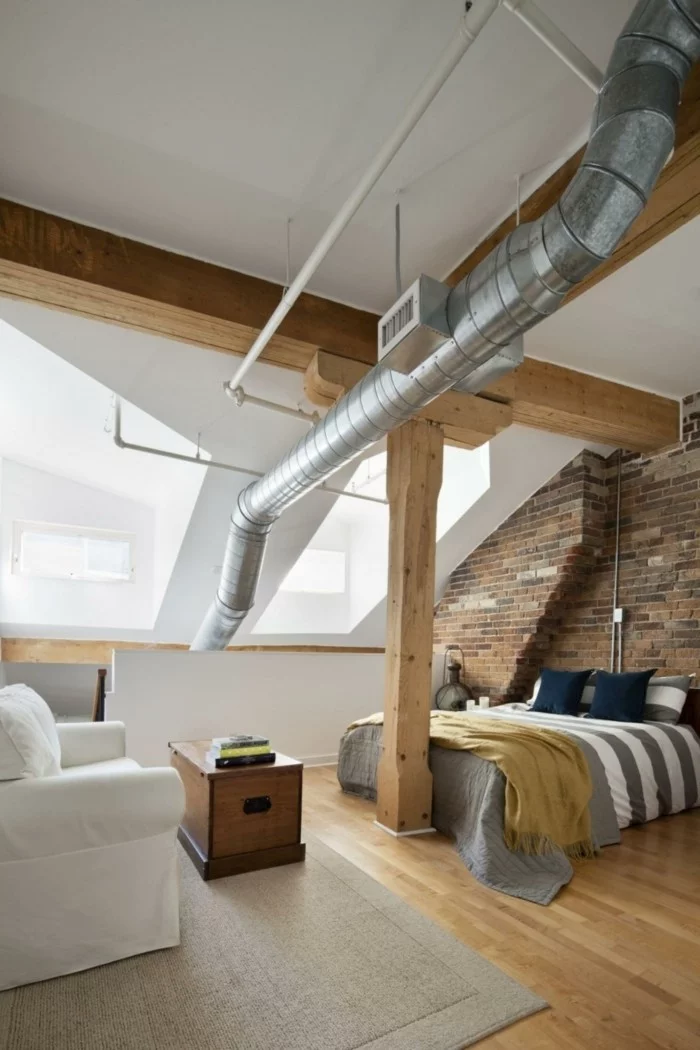Schlafzimmer mit Dachschräge mit weißen Wänden und Ziegelwand