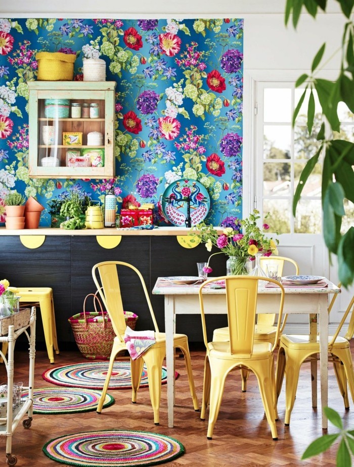 küchendesign mit floralen wandmustern und gelben küchenstühlen