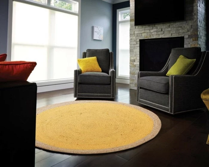 frischer runder Teppich in Gelb und graue Sessel mit farbigen Dekokissen