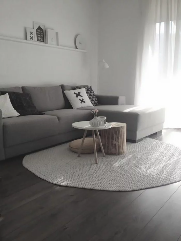 minimalistisches Wohnzimmer mit weißem Teppich in runder Form und Holztisch