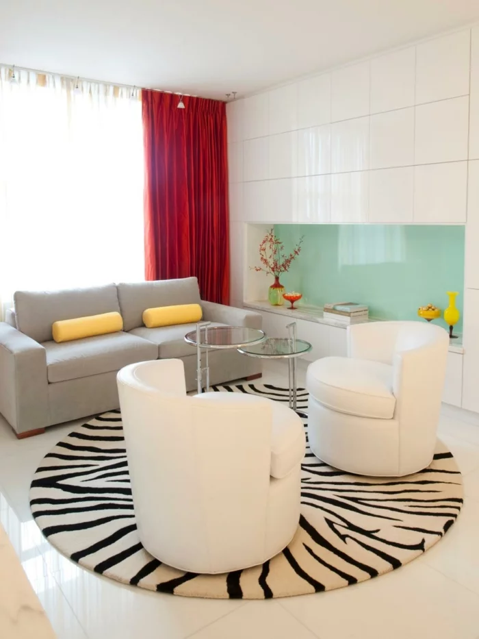 runder Teppich mit Zebra-Muster und weiße Sessel