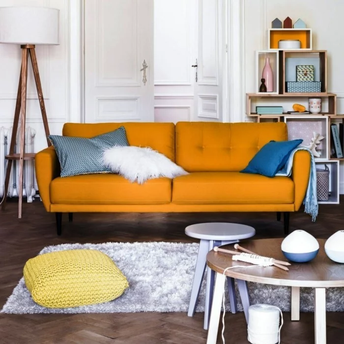 wohnideen wohnzimmer oranges sofa heller teppich dekokissen