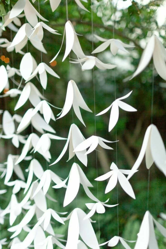 kreative Gartendeko mit Girlanden mit Papierblumen