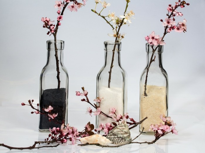 glasflaschen mit frühlingszweigen blüten frühlingsdekoration
