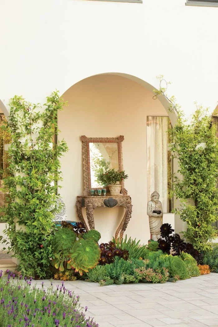 mediterrane Gartengestaltung mit Gartenskulptur, Spiegel und vielen Pflanzen