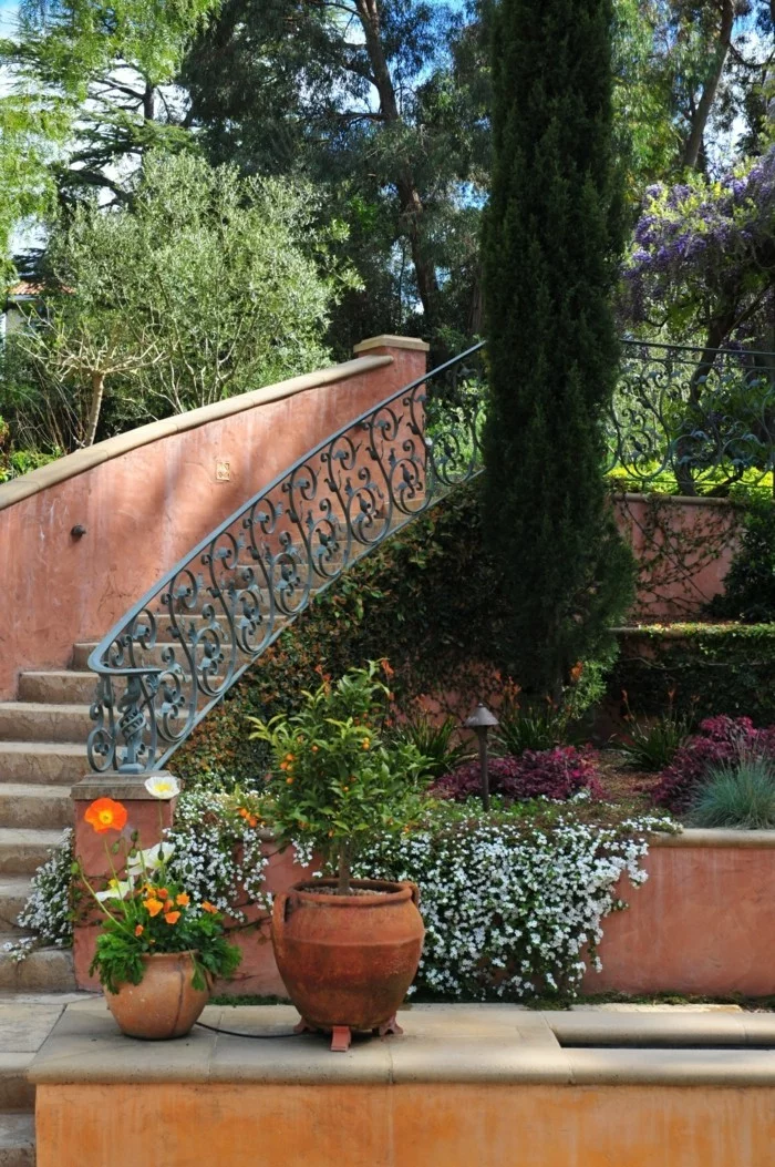 Gartentreppen mit einem eleganten Geländer und Pflanzengestaltung in Etagen