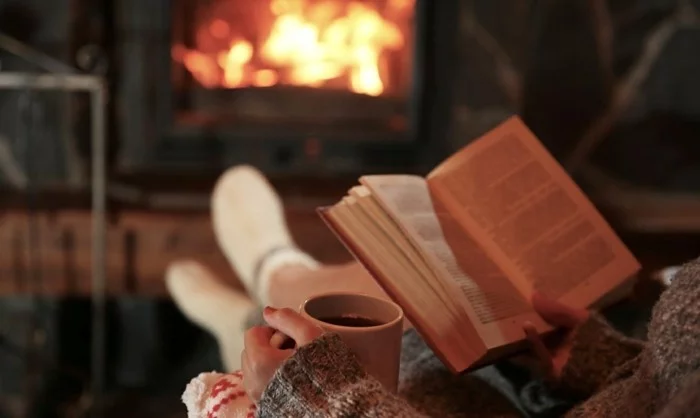 Hygge wohnen und ein Buch bei einer Tasse Tee lesen