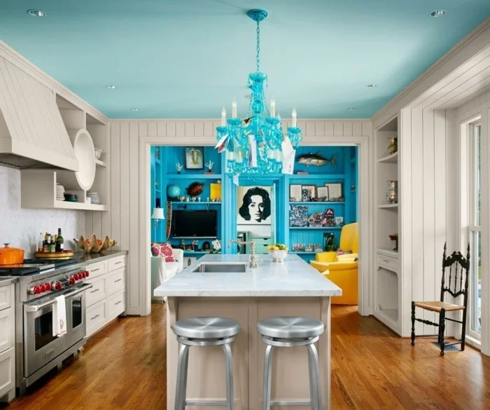 wohnküche mit weißer kücheninsel und blauer wohnwand