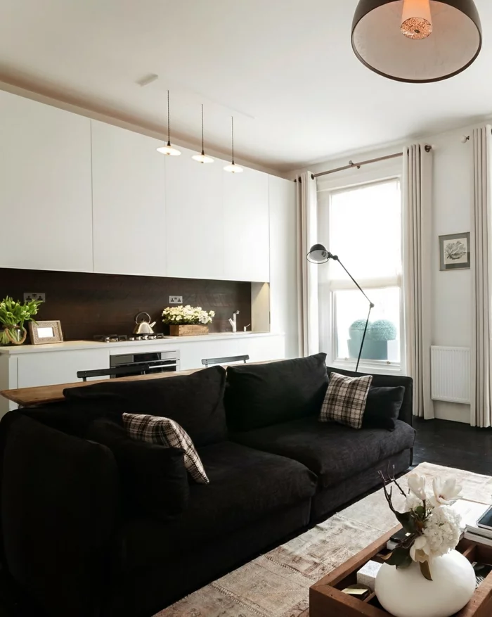 wohnküche weiße küchenschränke und schwarzes wohnzimmersofa