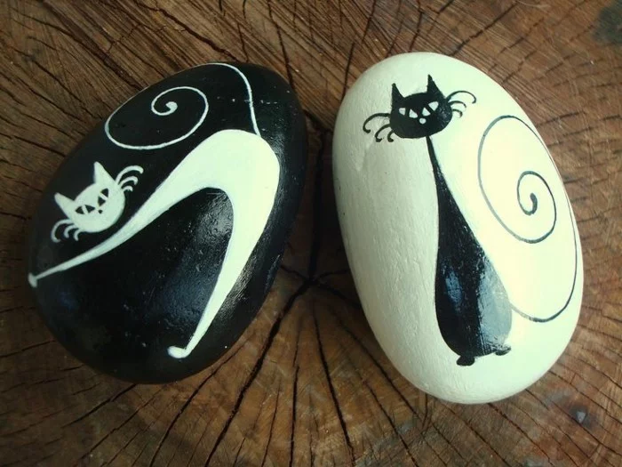 weiße und schwarze Katzen auf runden Steinen gemalt 