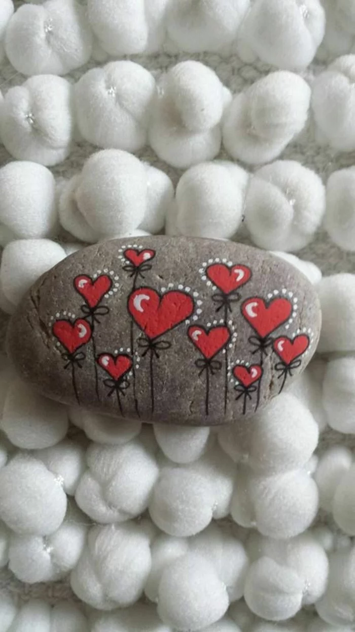 ovaler Stein mit kleinen Herzen bemalt 