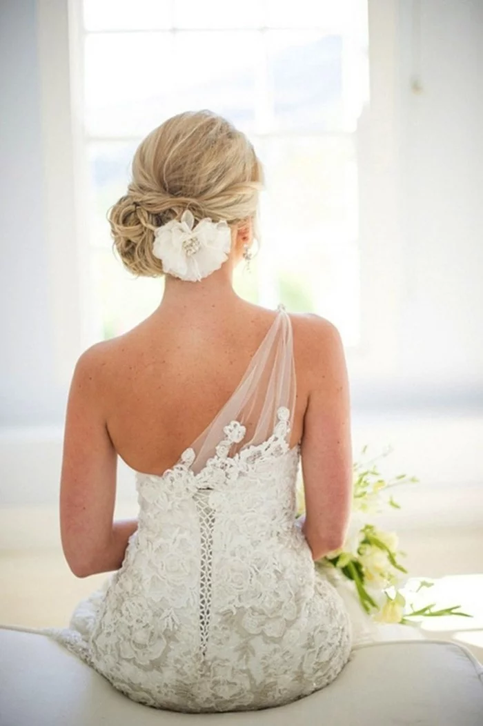 Brautfrisur mit Dutt und Blume-Haarschmuck 
