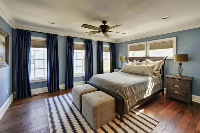 dunkelblaue Gardinen für Schlafzimmer, hellblaue Wände und Teppich mit Streifenmuster
