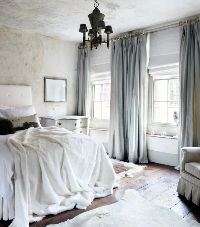 Gardinen für Schlafzimmer, weiße Bettwaren und Wände in Betonoptik