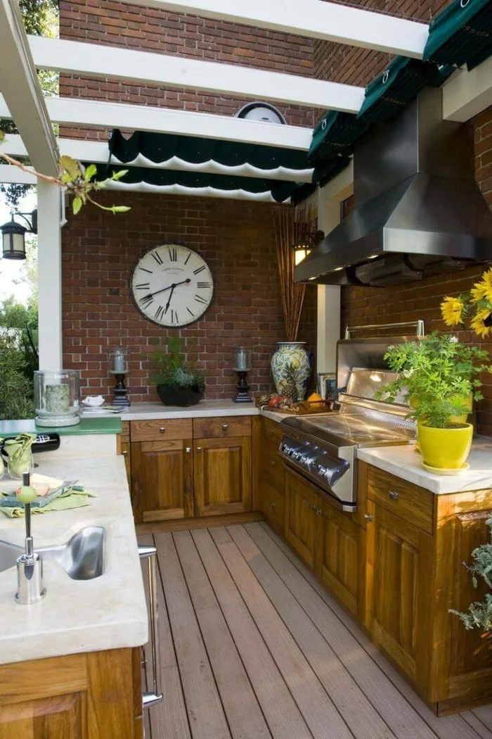 funktionale Außenküche mit Ziegelwand, viel Stauraum und Holzboden