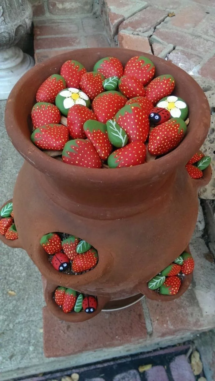 kreative Gartenideen mit Steinen als Erdbeeren oder Blumen
