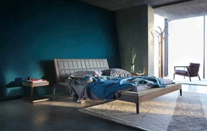 wohnideen schlafzimmer grauer boden blaue akzentwand und schöne blaue bettdecke