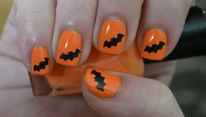 halloween nägel oranger nagellack mit fledermäusen