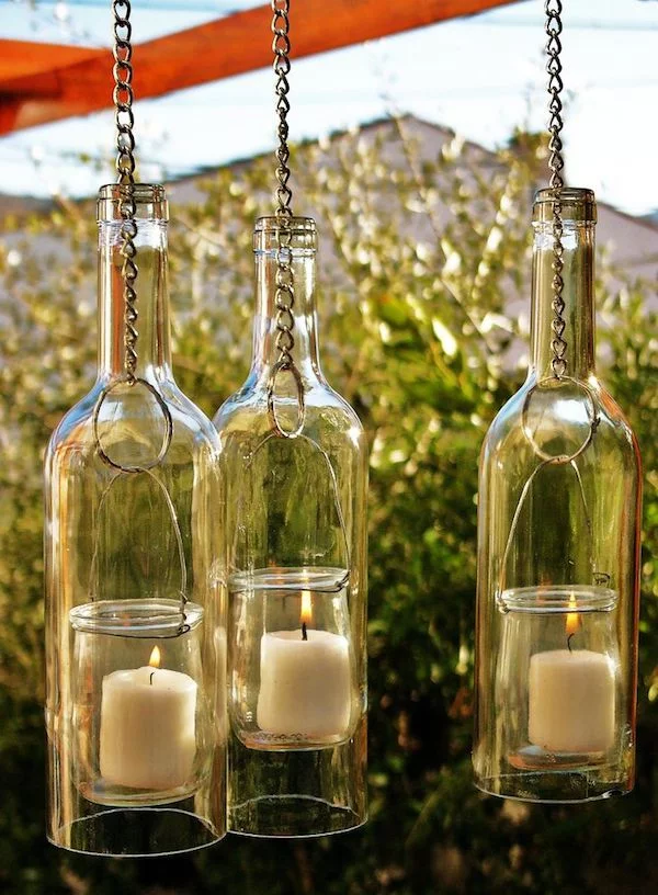 drei hängende Flaschenlampen aus leeren Weinflaschen mit Kerzen 