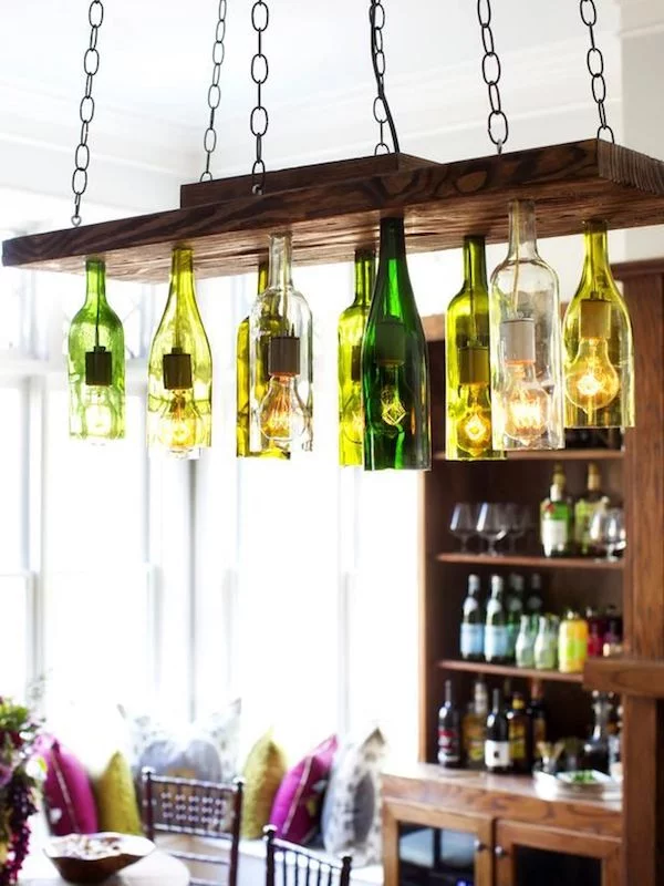 DIY Kronleuchter aus leeren Glasflaschen an einem Holzbrett 