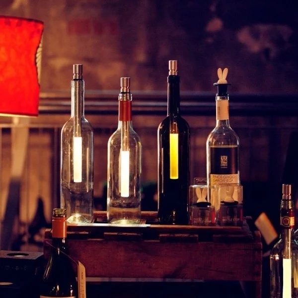 leere Weinflaschen als Flaschenlampen auf dem Tisch