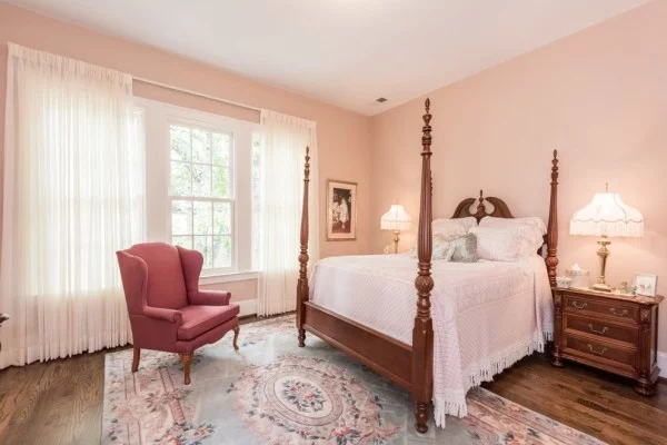 Schlafzimmer mit Wandfarbe Apricot und Sessel in Rosa