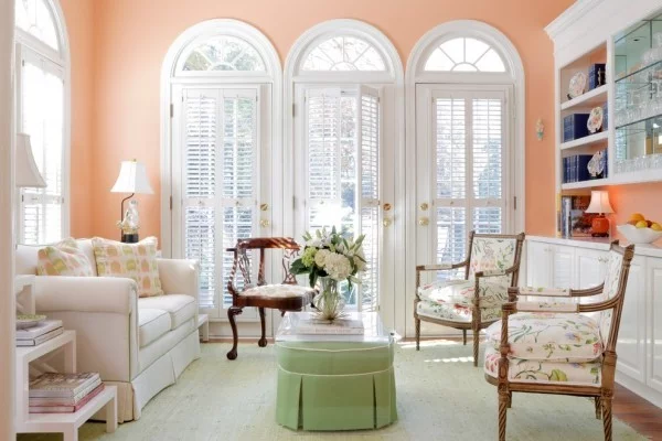 grüner Couchtisch, farbige Stühle und Wandfarbe Apricot
