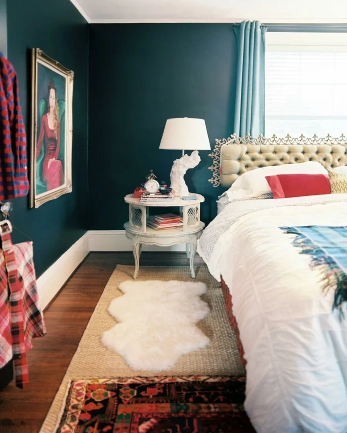 Schlafzimmer mit Wandfarbe Petrol und farbigen Textilien