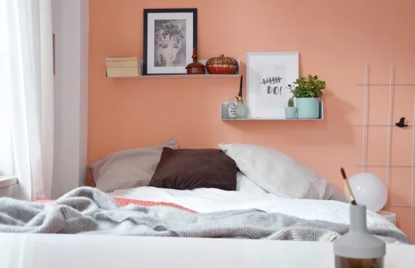 kleines Schlafzimmer mit Wandfarbe Apricot und Wandregalen