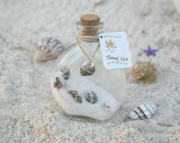 Glasflasche voller Sand und Muscheln als Gastgeschenk zur Hochzeit 