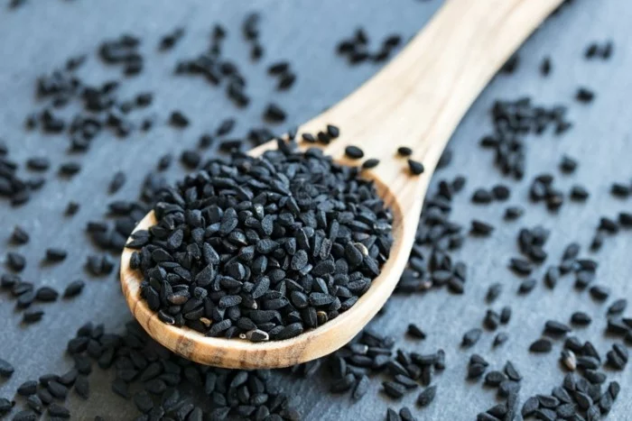 83825697 - black cumin seeds on a wooden spoon