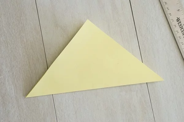 gelbes Blatt Papier in A4 Format in Dreieck gefaltet