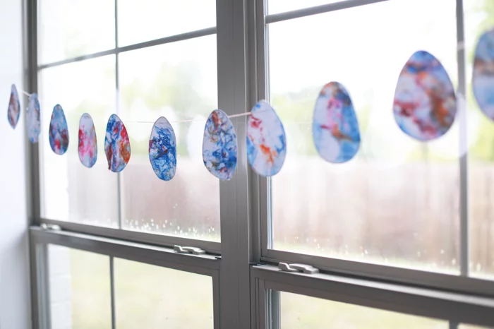 Fensterdeko basteln mit Kindern und Papiergirlande aus Ostereiern selber machen 