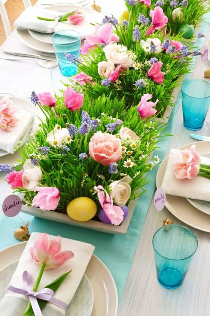 Tischdeko mit üppiger Blumendeko und farbigen Ostereiern
