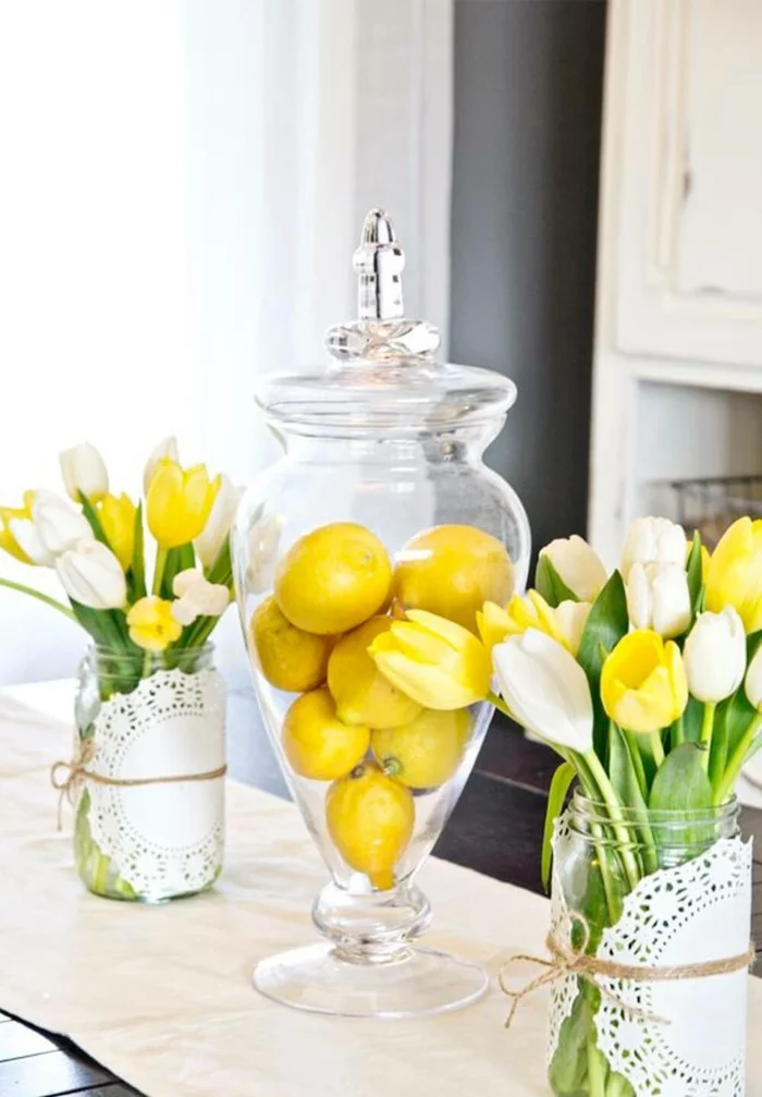 Tischdeko mit Tulpen und Zitronen in eleganten Glasgefäßen