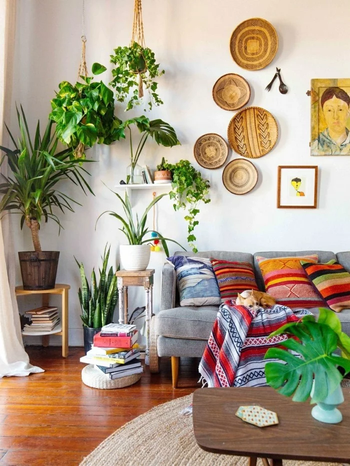 Grünpflanzen mit großen Blättern im eklektischen Wohnzimmer mit farbigen Textilien