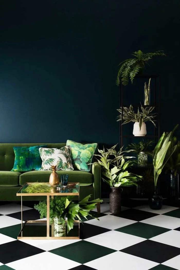 Grünpflanzen, grünes Sofa, dunkelgrüne Wand und Boden in Schachbrettoptik