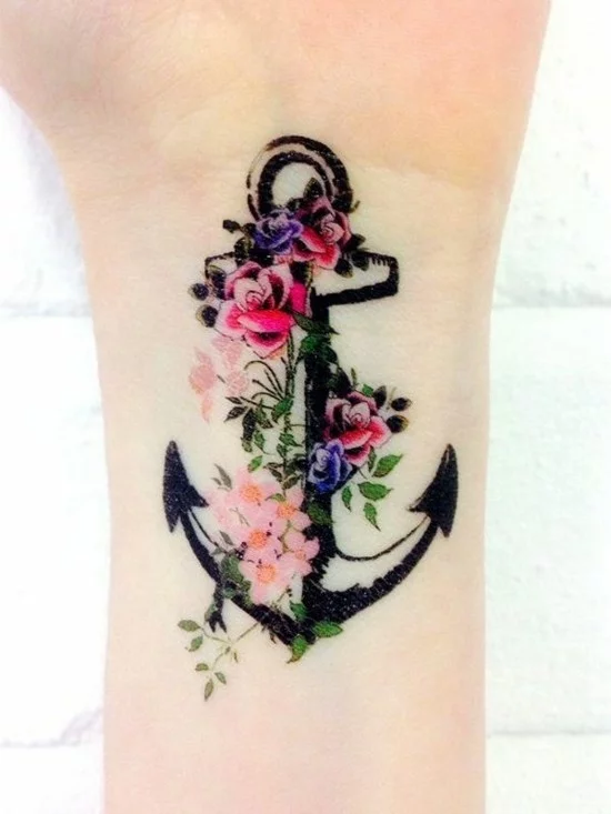 Anker Tattoo mit bunten Blumen am Handgelenk