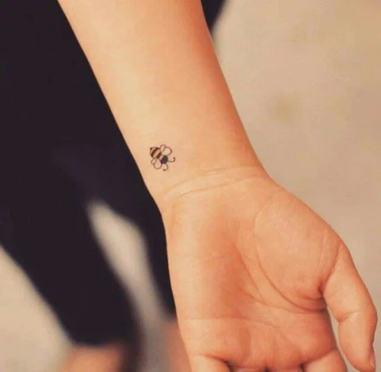 Mikro Tattoo mit Biene am Handgelenk einer Frau