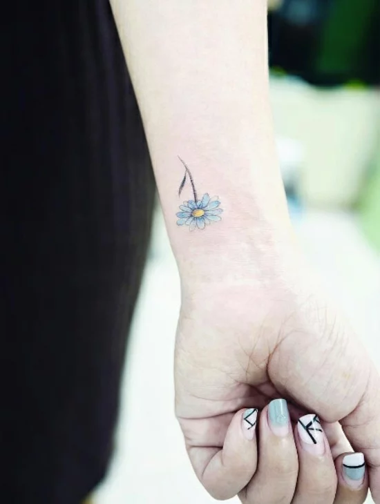 blaue Margerite als Tattoo am Handgelenk