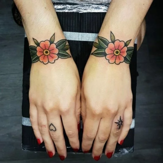 Tattoo Handgelenk Design mit bunten Blumen und kleinen Fingertattoos