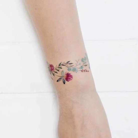 zarte bunte Blumen als Armband-Tattoo am Handgelenk