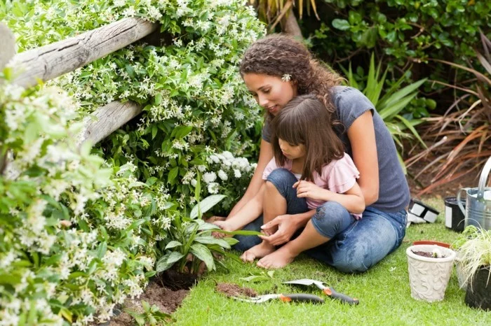 Mutter und Tochter formen englische Rasenkanten im Garten 