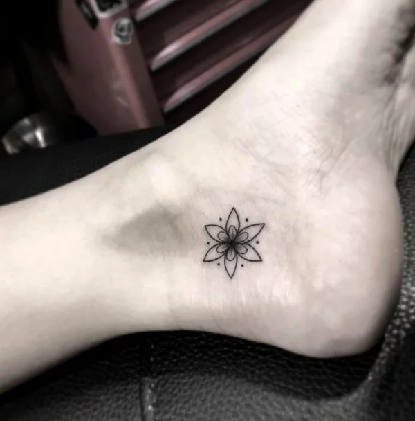 grafisches Tattoo mit Blume am Fußgelenk 