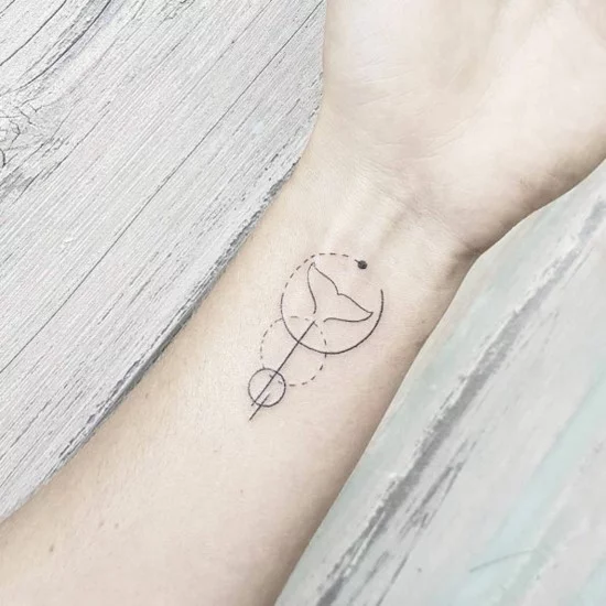 grafisches, kleines Tattoo am Handgelenk mit Kreisen und Walschwanz 